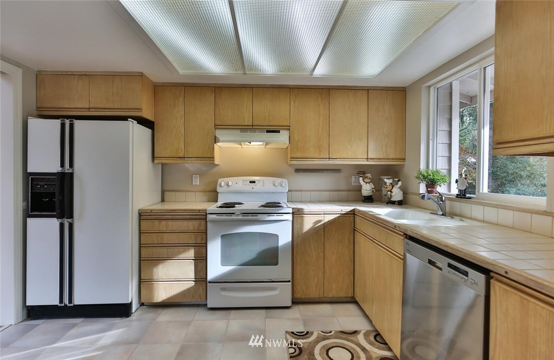 404 170th Place Southwest Bothell, WA 98012 - Photo 9 of 25 a kitchen with a sink a refrigerator and cabinets