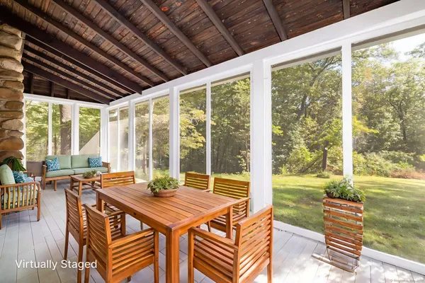 a view of a dining room with furniture large windows and wooden floor