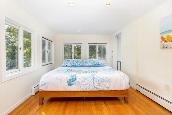 a bedroom with a bed and wooden floor
