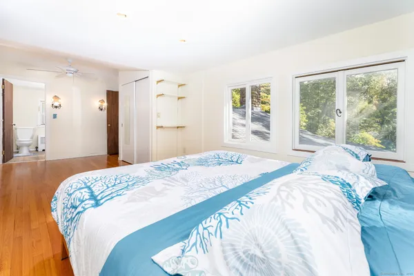 a bedroom with a bed and a large window