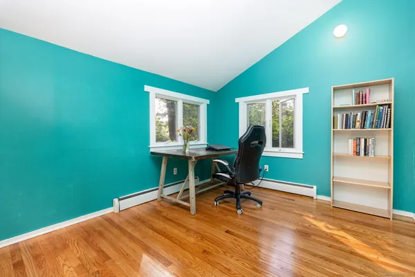 a view of a workspace with furniture and a window
