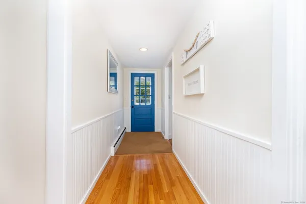 a view of a hallway with wooden floor and entryway
