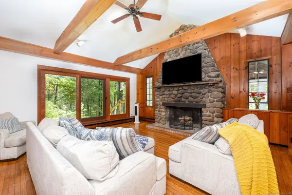a living room with furniture a flat screen tv and a fireplace