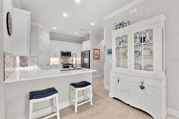 a kitchen with granite countertop white cabinets and stainless steel appliances