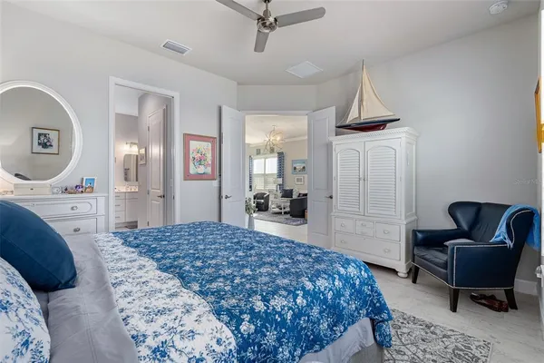 a bedroom with a large bed and a chandelier