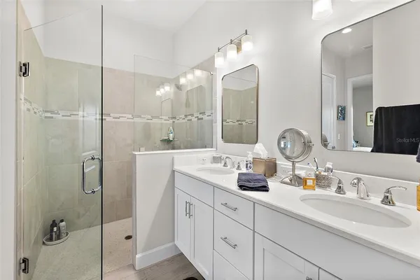 a bathroom with double vanity sinks and a mirror