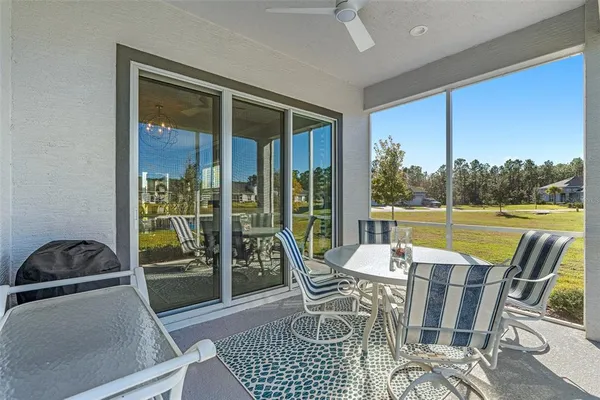 a dining room with furniture and a floor to ceiling window