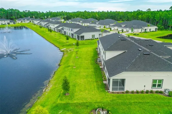 an aerial view of a house with a garden and lake view
