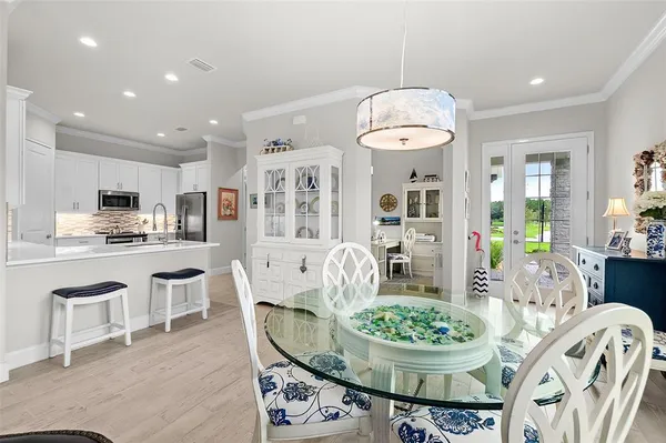 a kitchen with stainless steel appliances granite countertop a stove a kitchen island a dining table and chairs