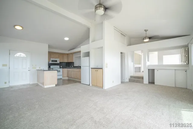a view of a kitchen with a sink and a refrigerator
