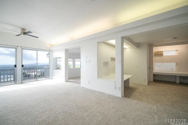 a view of a big room with windows and chandelier fan