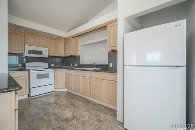 a kitchen with a refrigerator a stove top oven and white cabinets