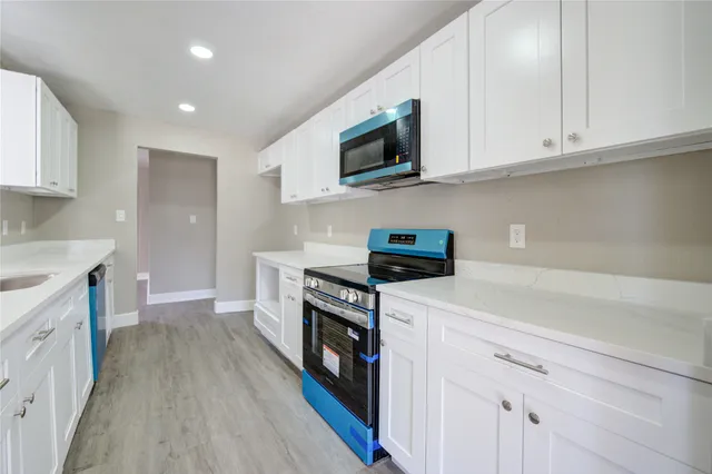 a kitchen with stainless steel appliances granite countertop a stove a sink and a microwave