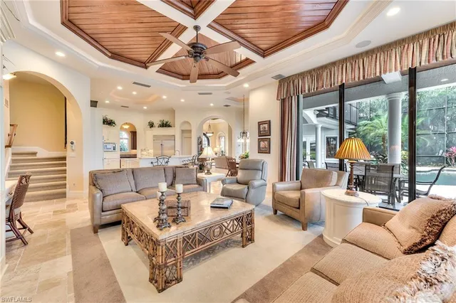 a living room with furniture a clock and a chandelier