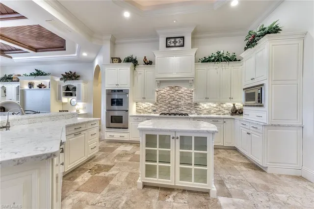 a dining hall with stainless steel appliances kitchen island granite countertop a dining table and chairs