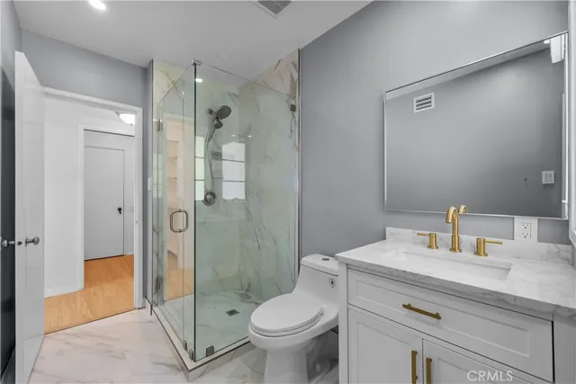 a view of an empty room with wooden floor and windows