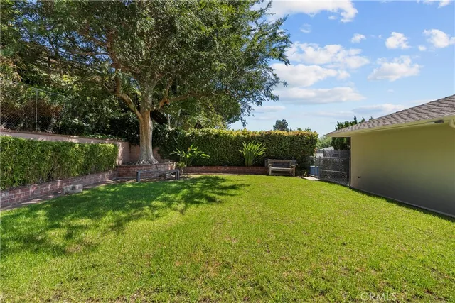 a view of house with backyard and a garden