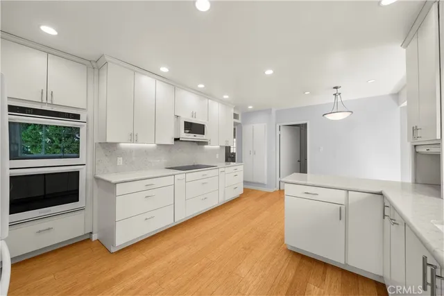 a large kitchen with stainless steel appliances kitchen island granite countertop a sink and cabinets