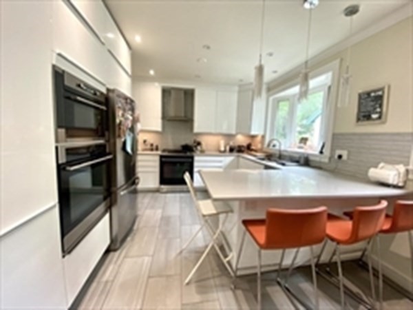 71 Mason Terrace, Unit 71 Brookline, MA 02446 - Photo 1 of 1 a kitchen with stainless steel appliances kitchen island granite countertop a sink and cabinets