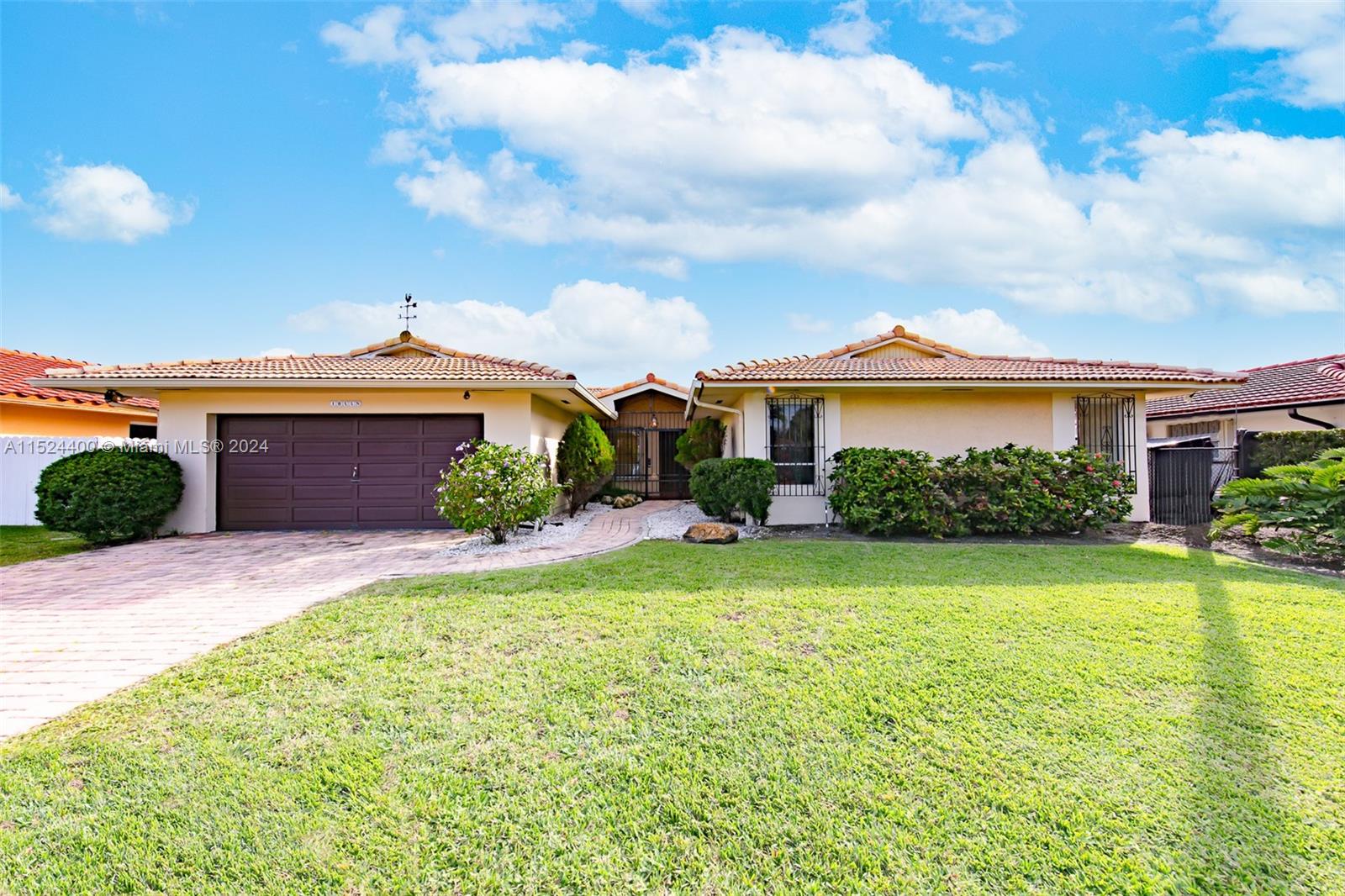 10448 Southwest 23rd Street Miami, FL 33165 - Photo 1 of 35 a front view of a house with garden
