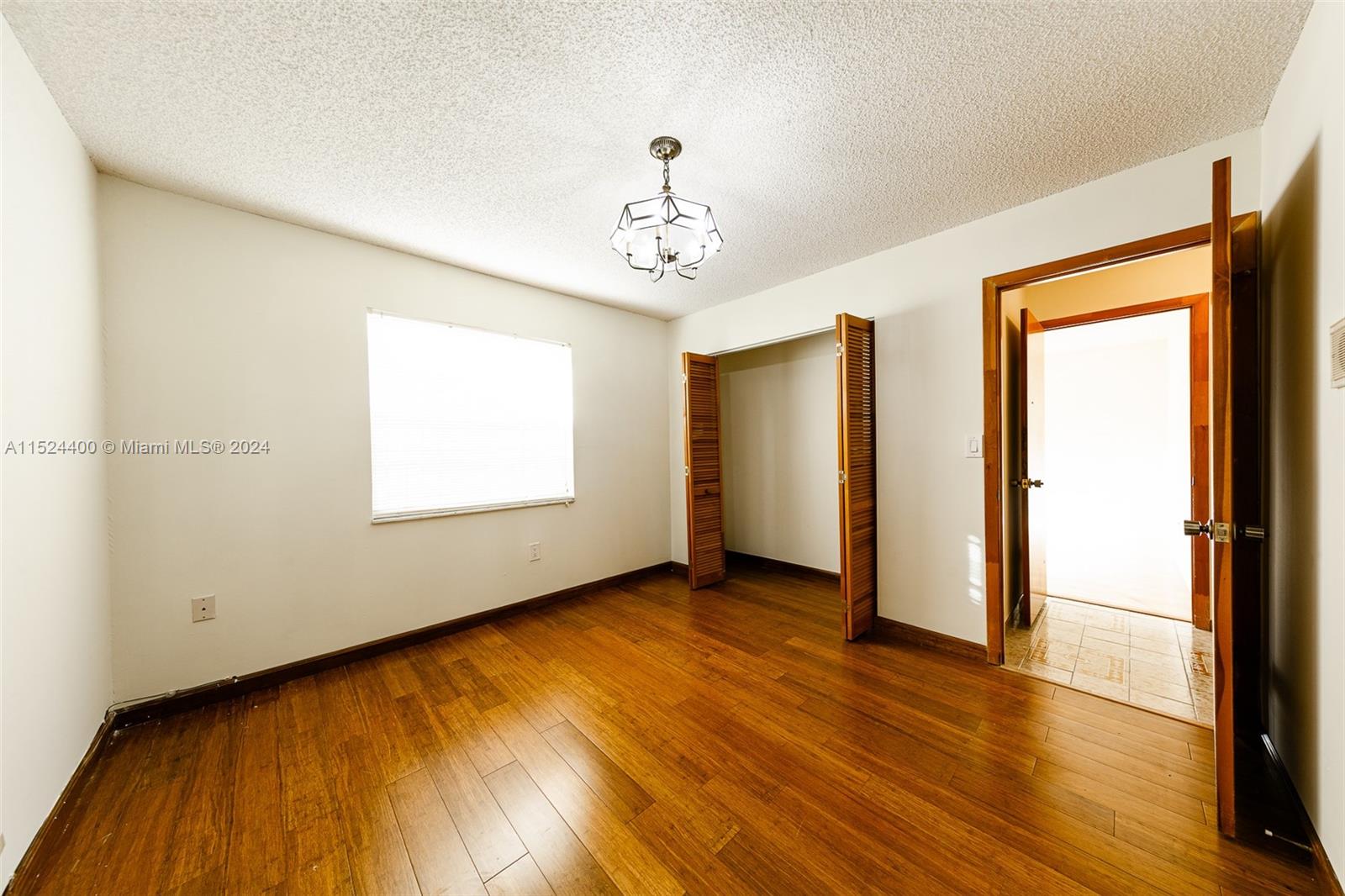 10448 Southwest 23rd Street Miami, FL 33165 - Photo 17 of 35 a view of an empty room with wooden floor and a window