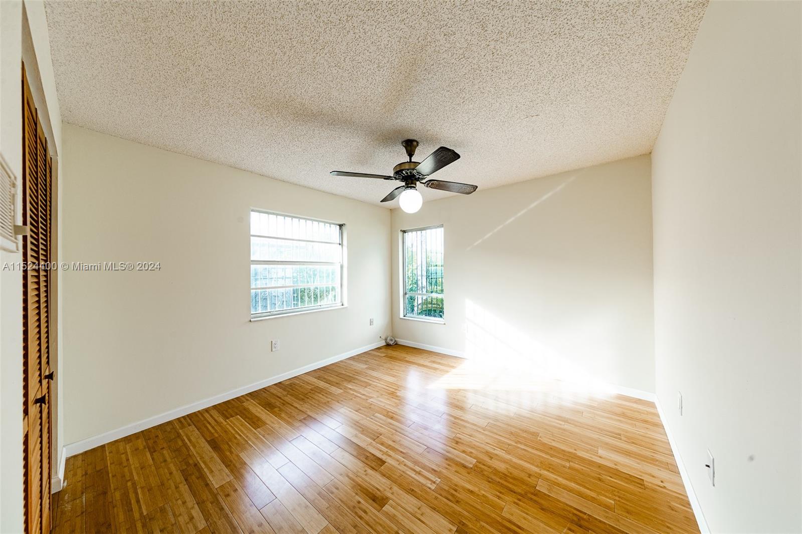 10448 Southwest 23rd Street Miami, FL 33165 - Photo 18 of 35 a view of empty room with wooden floor and fan