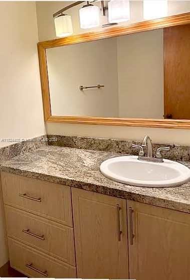 10448 Southwest 23rd Street Miami, FL 33165 - Photo 20 of 35 a bathroom with a granite countertop sink and a mirror