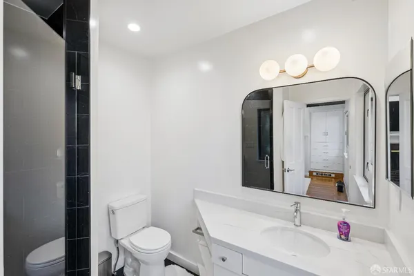a bathroom with a toilet sink and mirror