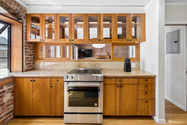 a kitchen with granite countertop a stove and a wooden cabinets