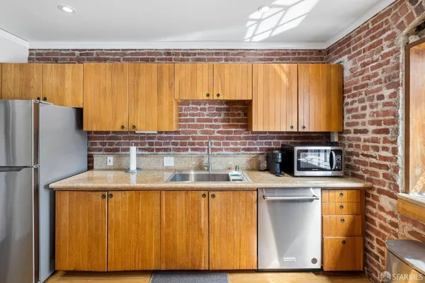 a kitchen with stainless steel appliances granite countertop a refrigerator and a sink