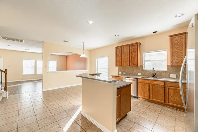 a kitchen with stainless steel appliances granite countertop a stove top oven sink and cabinets