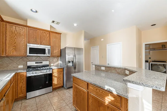 a kitchen with stainless steel appliances granite countertop a sink stove and refrigerator