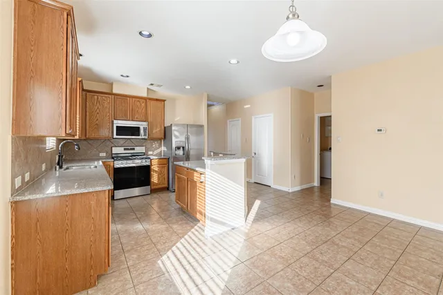 a large kitchen with a sink stainless steel appliances and cabinets