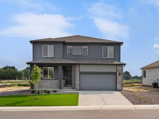 a front view of a house with a garden and yard