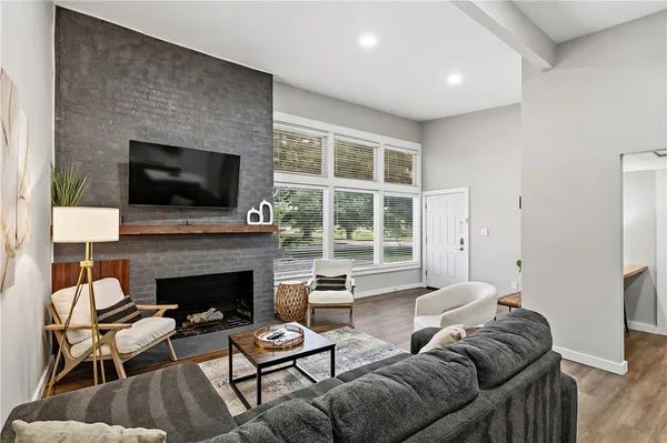 a living room with furniture a flat screen tv and a fireplace