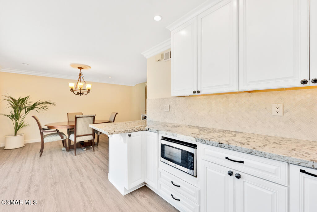 2685 Velarde Drive Thousand Oaks, CA 91360 - Photo 12 of 40 a kitchen with a stove and white cabinets with wooden floor