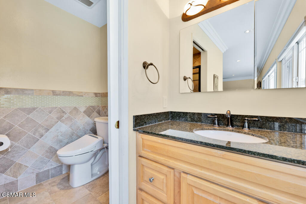 2685 Velarde Drive Thousand Oaks, CA 91360 - Photo 23 of 40 a bathroom with a granite countertop sink a toilet and a mirror