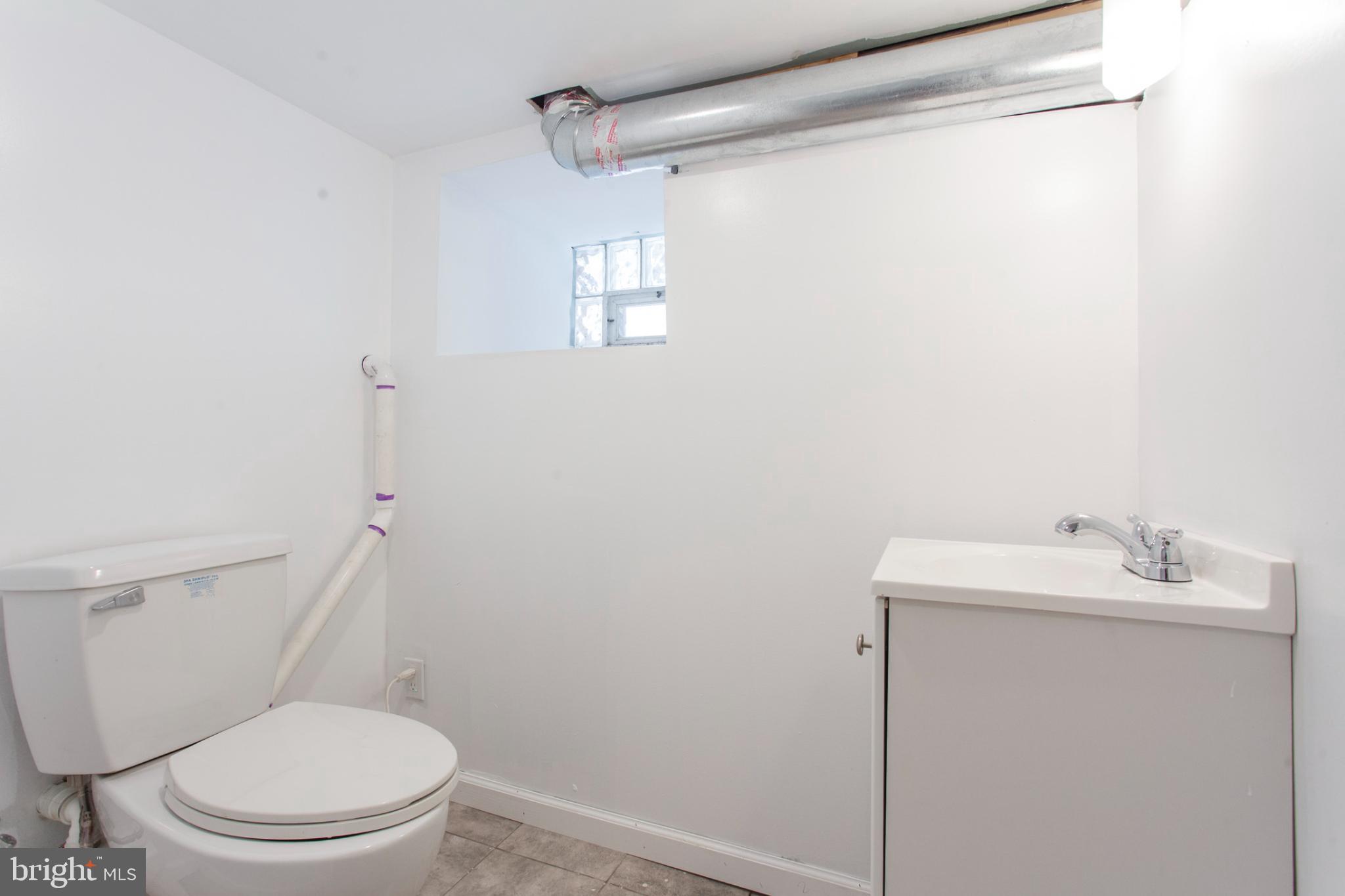 5330 Pentridge Street Philadelphia, PA 19143 - Photo 13 of 14 a white toilet sitting next to a bathroom sink