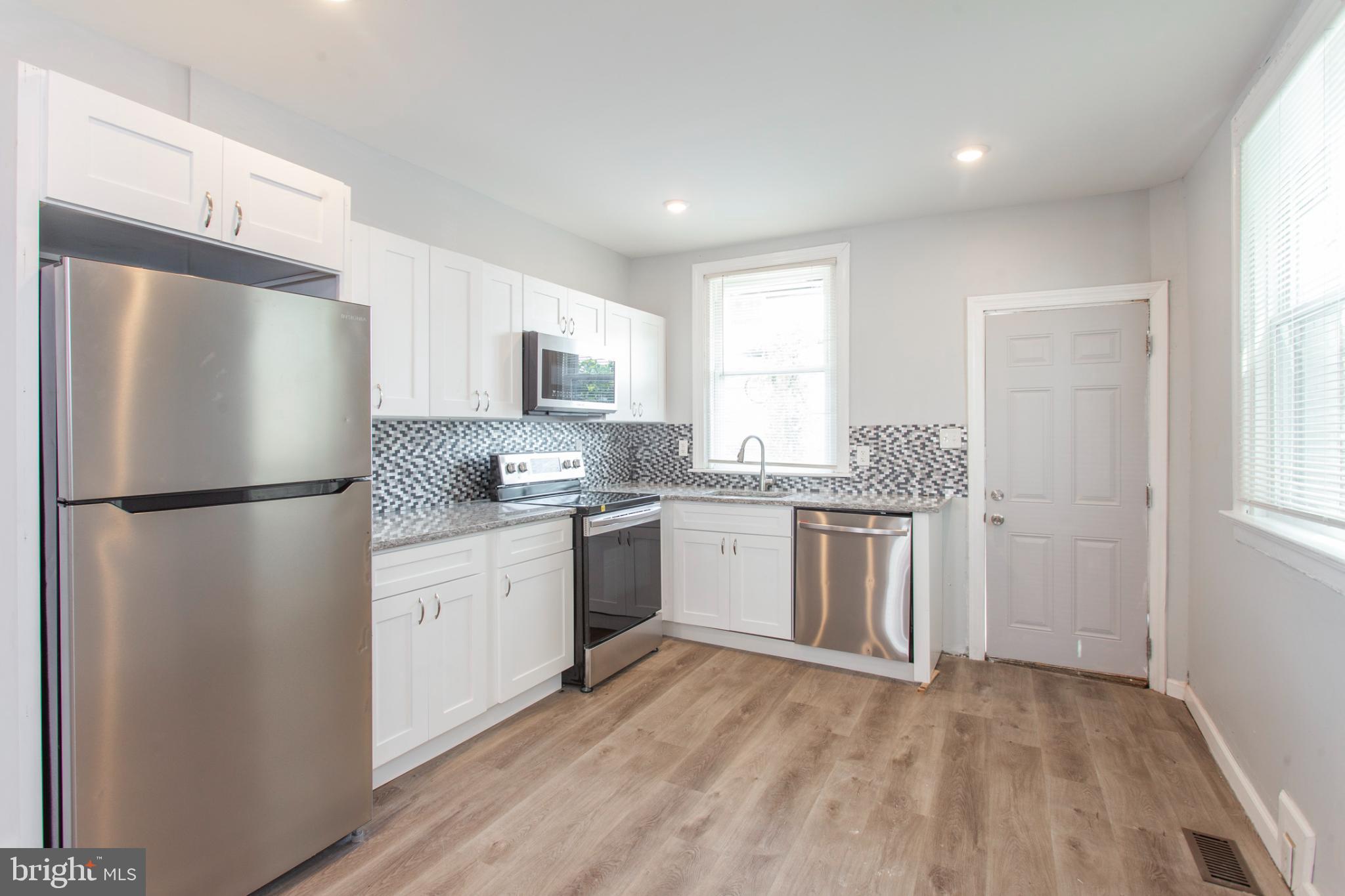 5330 Pentridge Street Philadelphia, PA 19143 - Photo 2 of 14 a kitchen with a refrigerator stove top oven and sink