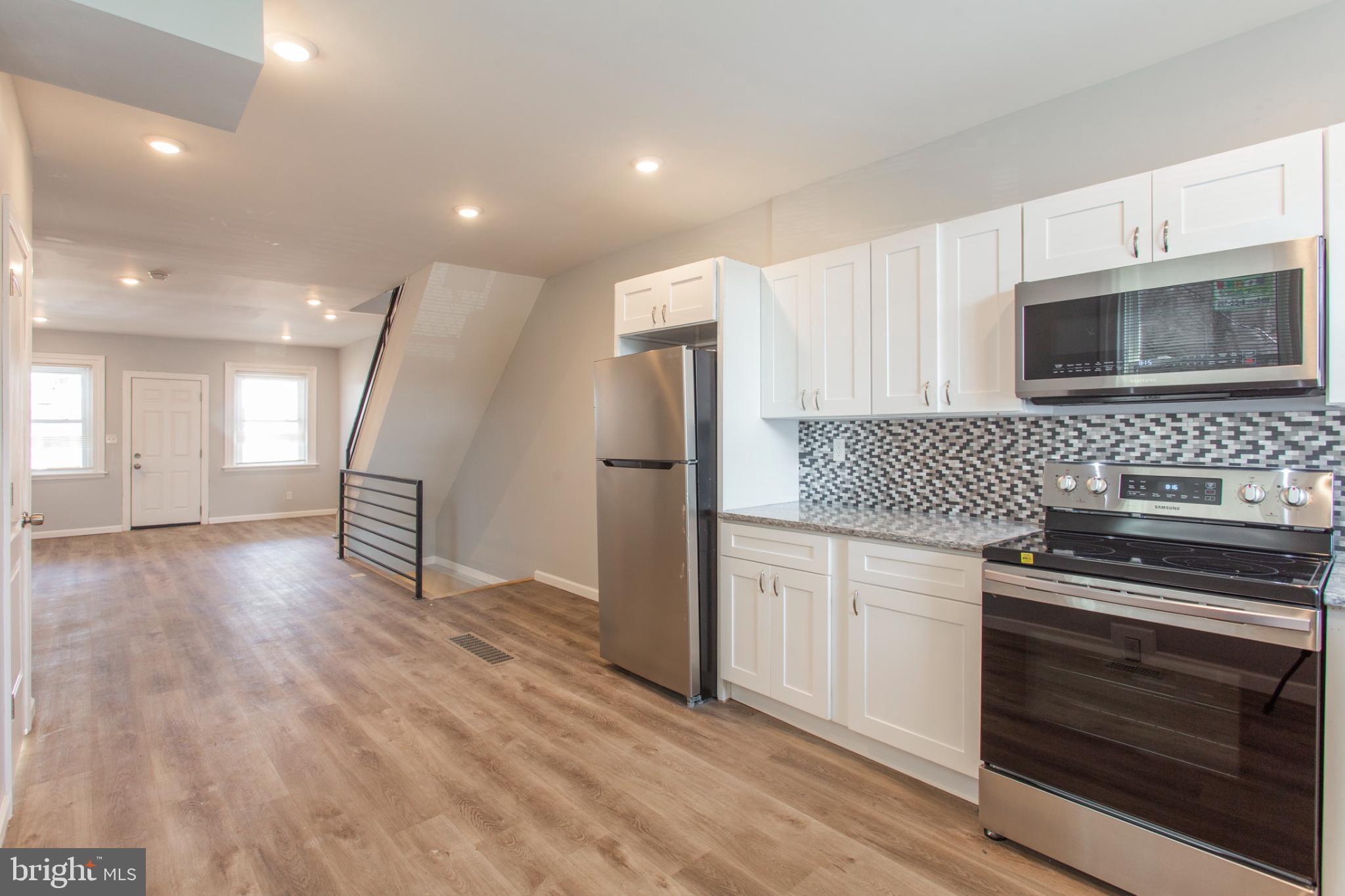 5330 Pentridge Street Philadelphia, PA 19143 - Photo 3 of 14 a kitchen with granite countertop a stove a sink and a refrigerator