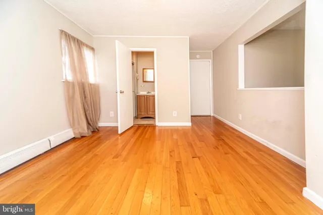 a view of a room with wooden floor and a window