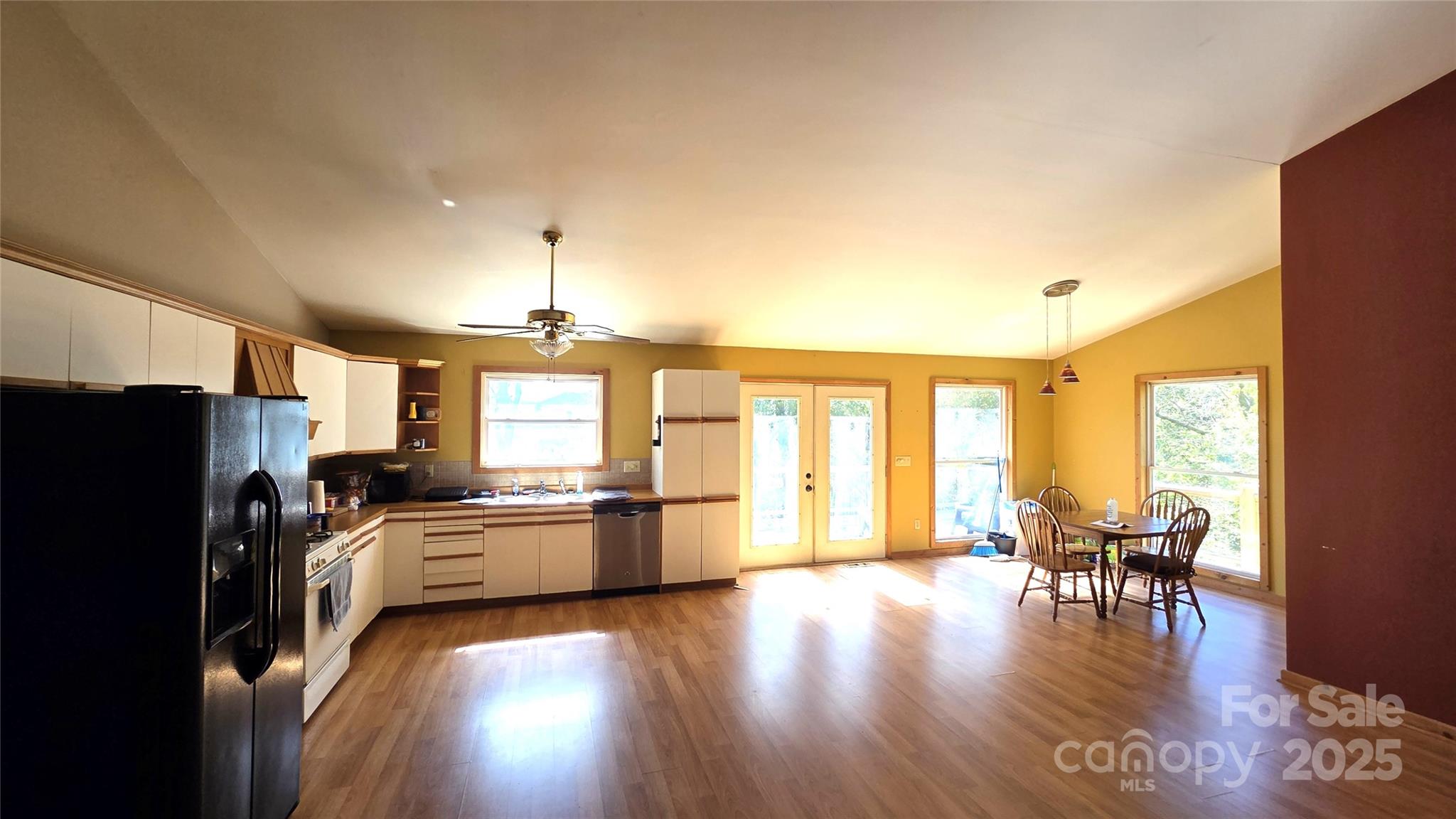 68 Garden Ridge Clyde, NC 28721 - Photo 5 of 16 a kitchen with granite countertop a refrigerator a stove top oven a dining table and chairs with wooden floor
