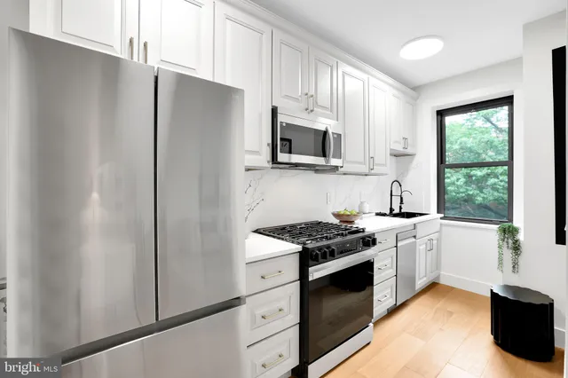 a kitchen with stainless steel appliances granite countertop a stove a refrigerator and a sink
