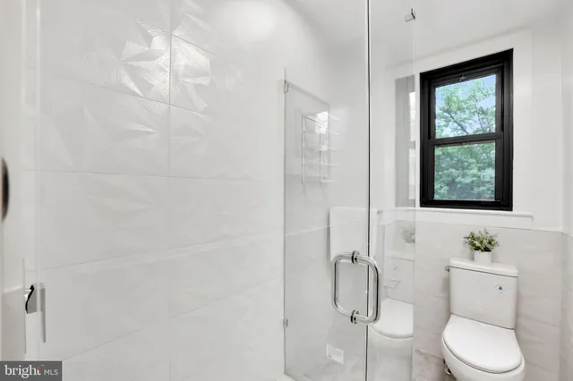 a bathroom with a granite countertop toilet a sink and shower