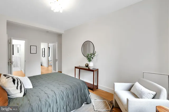 a bedroom with a bed couch and a mirror