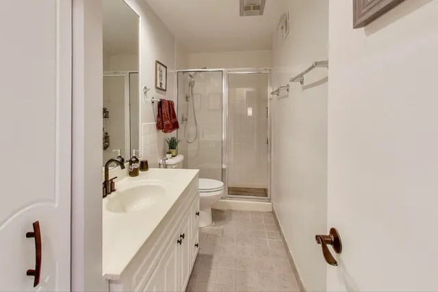 a bathroom with a sink a toilet a mirror and shower