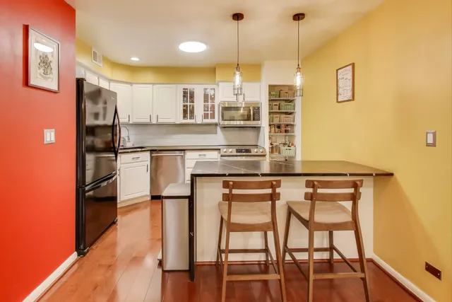 a kitchen with stainless steel appliances granite countertop a stove a sink and a refrigerator