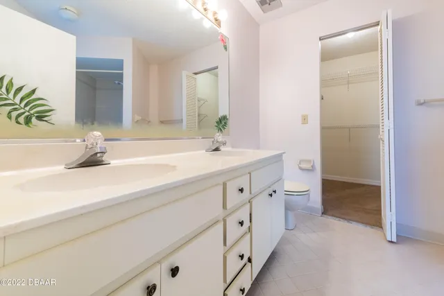 a spacious bathroom with double sink and a mirror