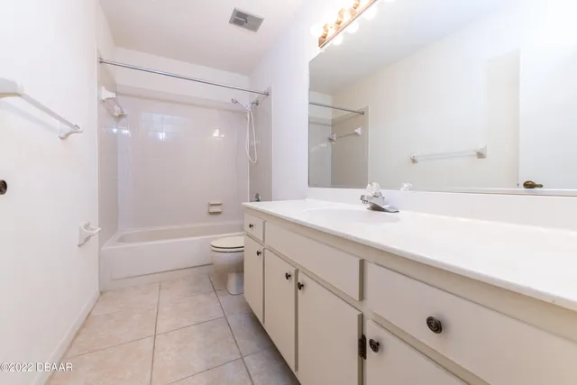 a spacious bathroom with a granite countertop sink a toilet and a bathtub