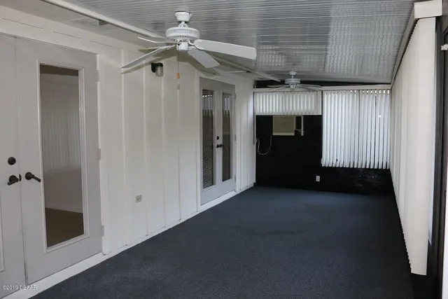 a view of a hallway with a ceiling fan